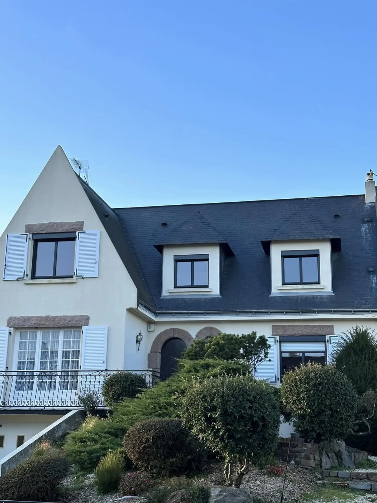 Maison familiale ardoise avec fenêtres et volets blancs rénovés