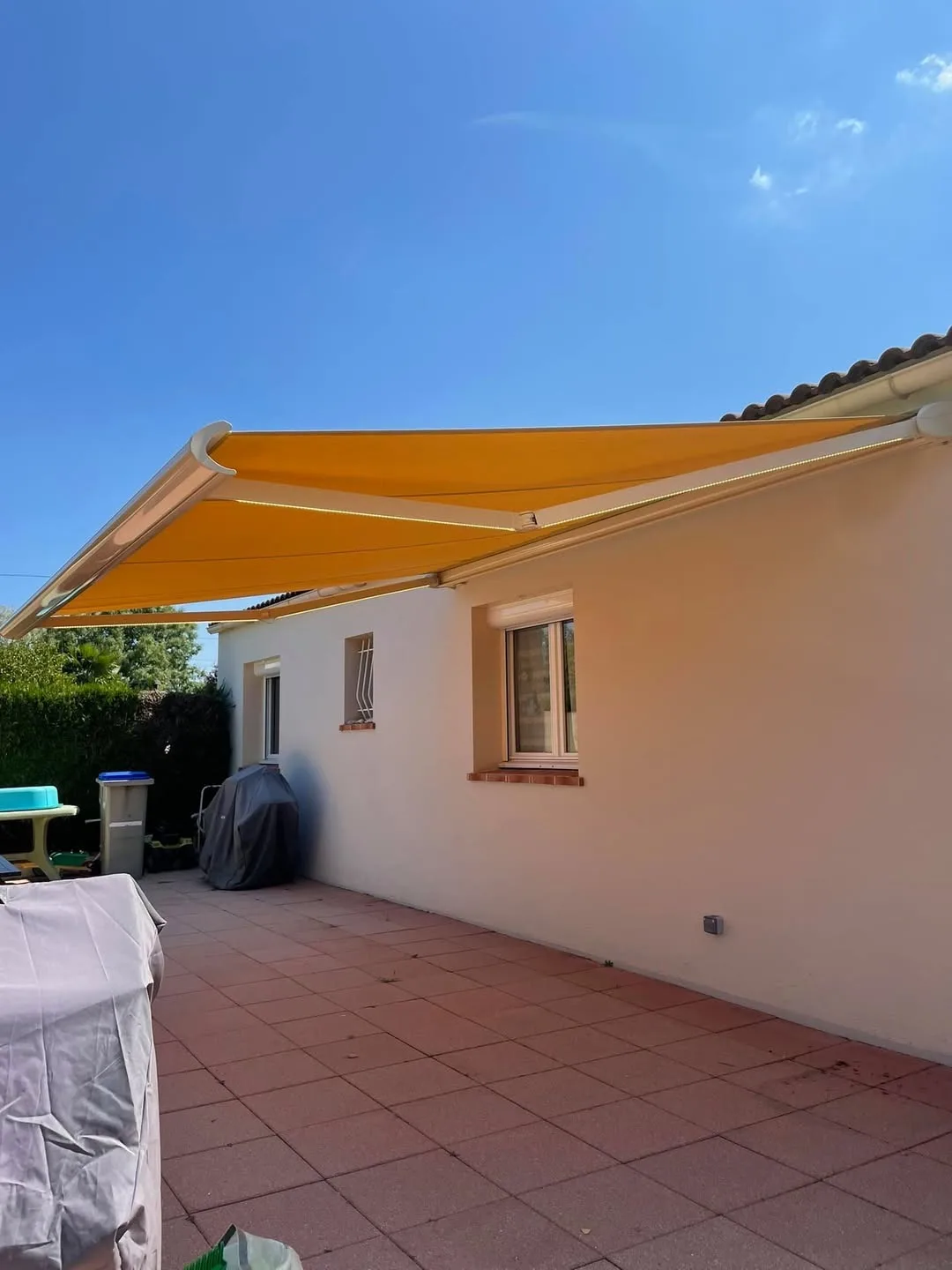Store banne motorisé jaune déployé sur terrasse