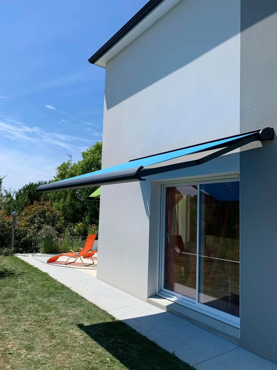 Store banne motorisé bleu sur terrasse de maison