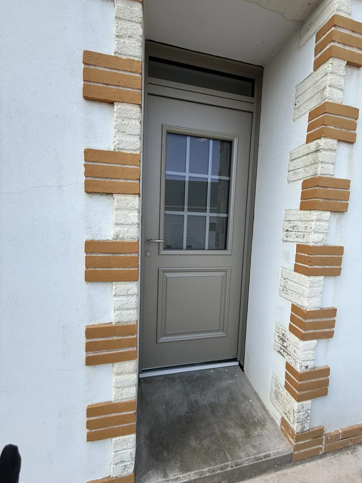 Porte d'entrée PVC anthracite contemporaine sur façade pierre