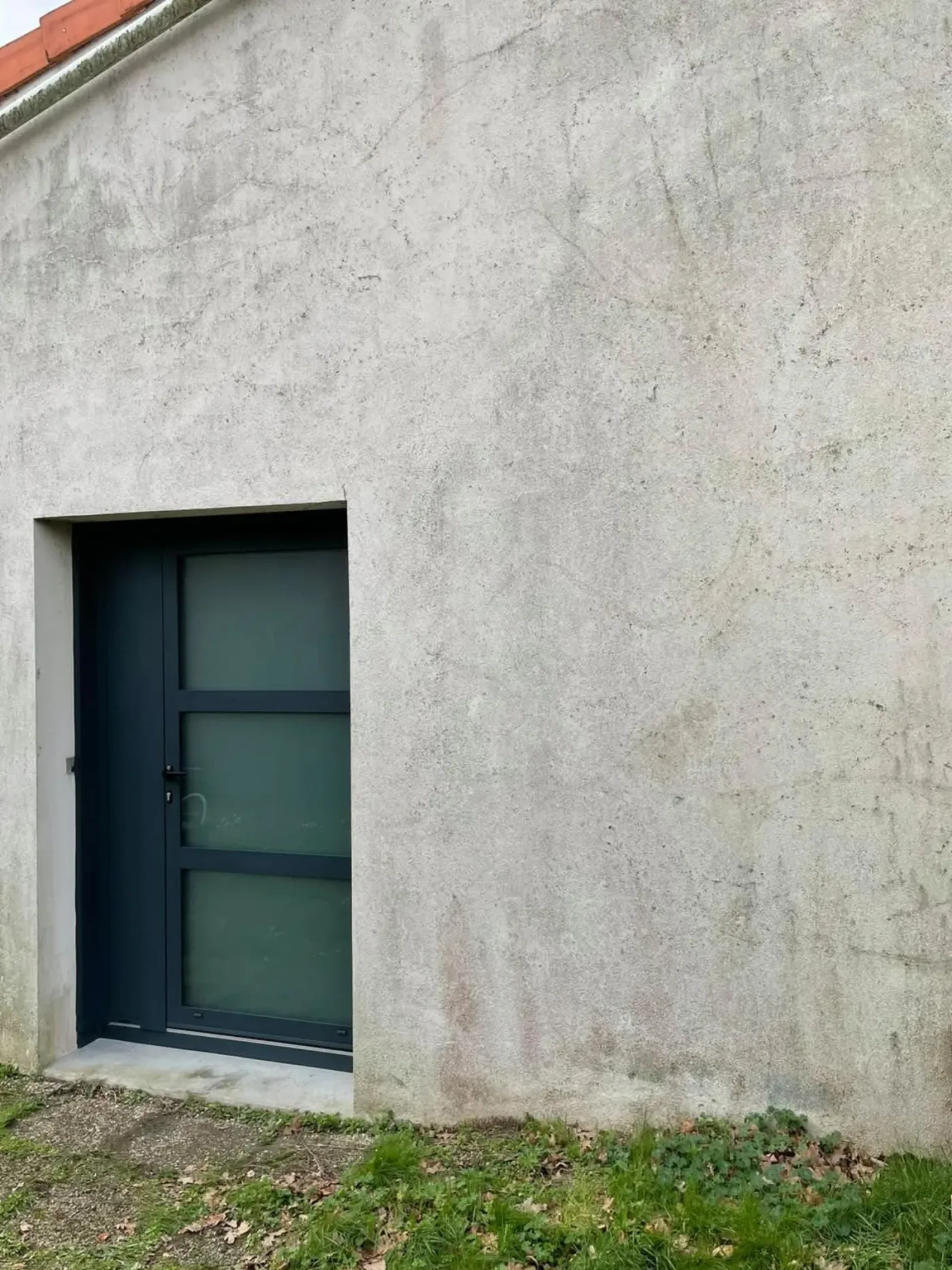 Porte d'entrée aluminium anthracite vitrée sur bâtiment crépi