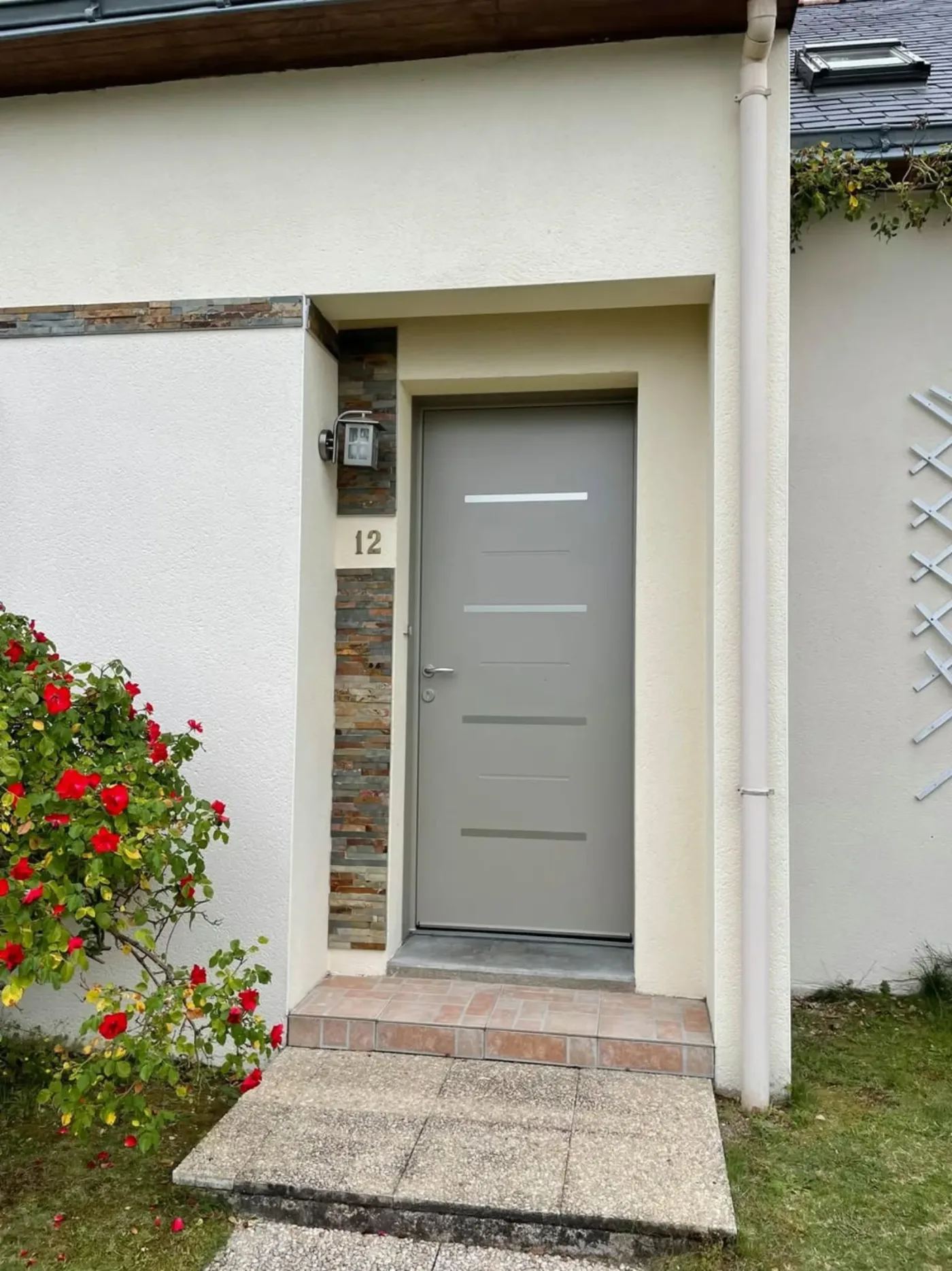 Porte d'entrée aluminium gris clair contemporaine avec encadrement pierre