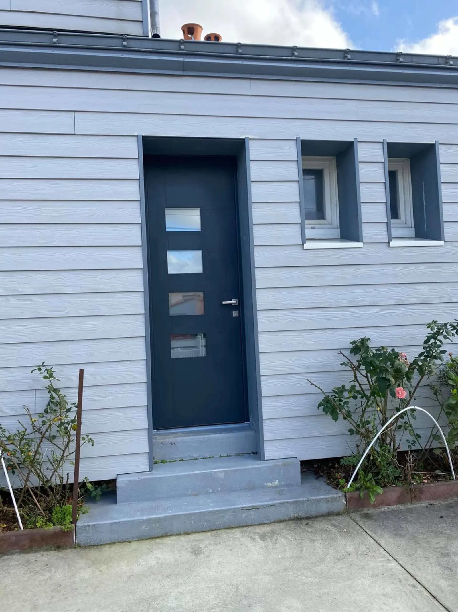 Porte d'entrée aluminium anthracite vitrée sur bardage blanc