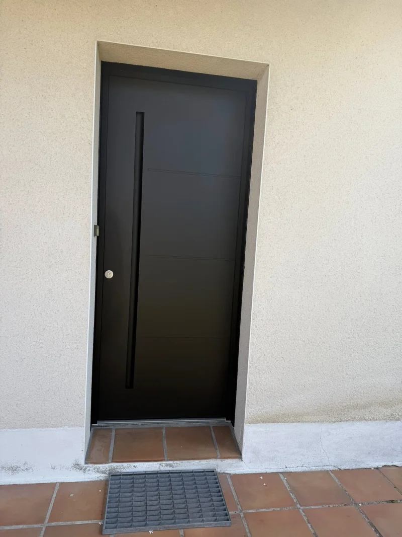Porte d'entrée aluminium noire avec longue poignée verticale design